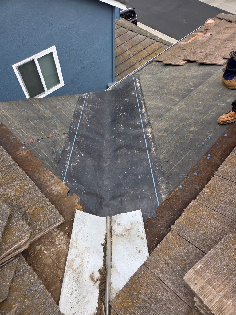 Ongoing tile roof repair in Carmel Valley showing roof valley work in progress